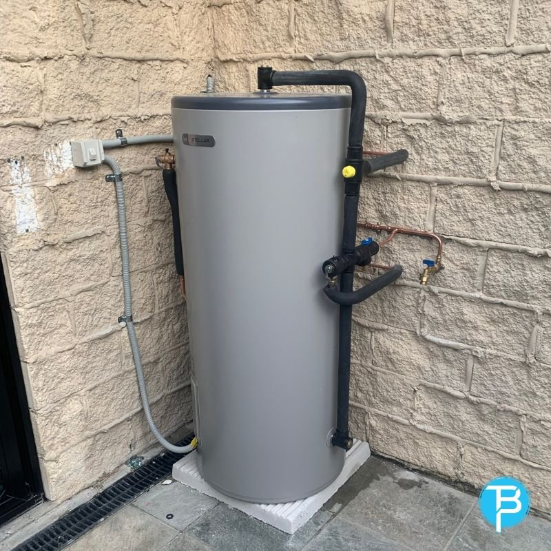 Heat pump hot water unit set up beside a home